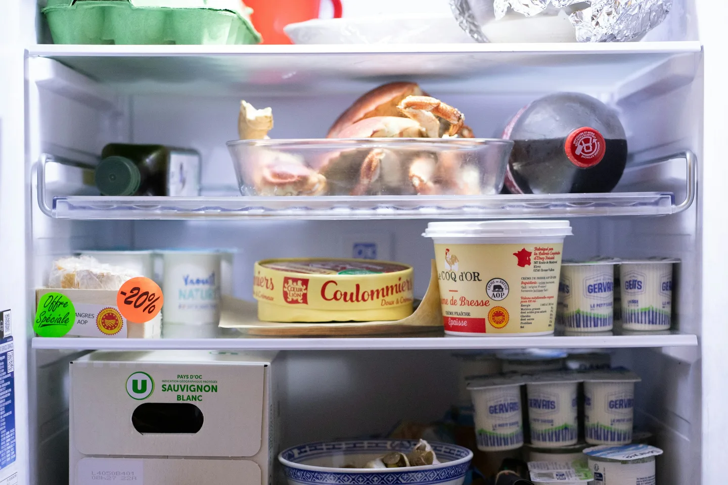 Открытый бытовой холодильник с полками и продуктами.